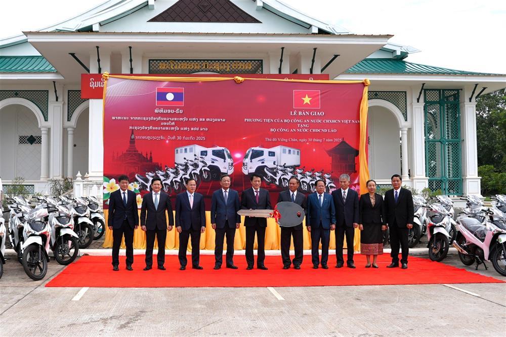 Minister Luong Tam Quang presents equipment and vehicles to Lao MPS.