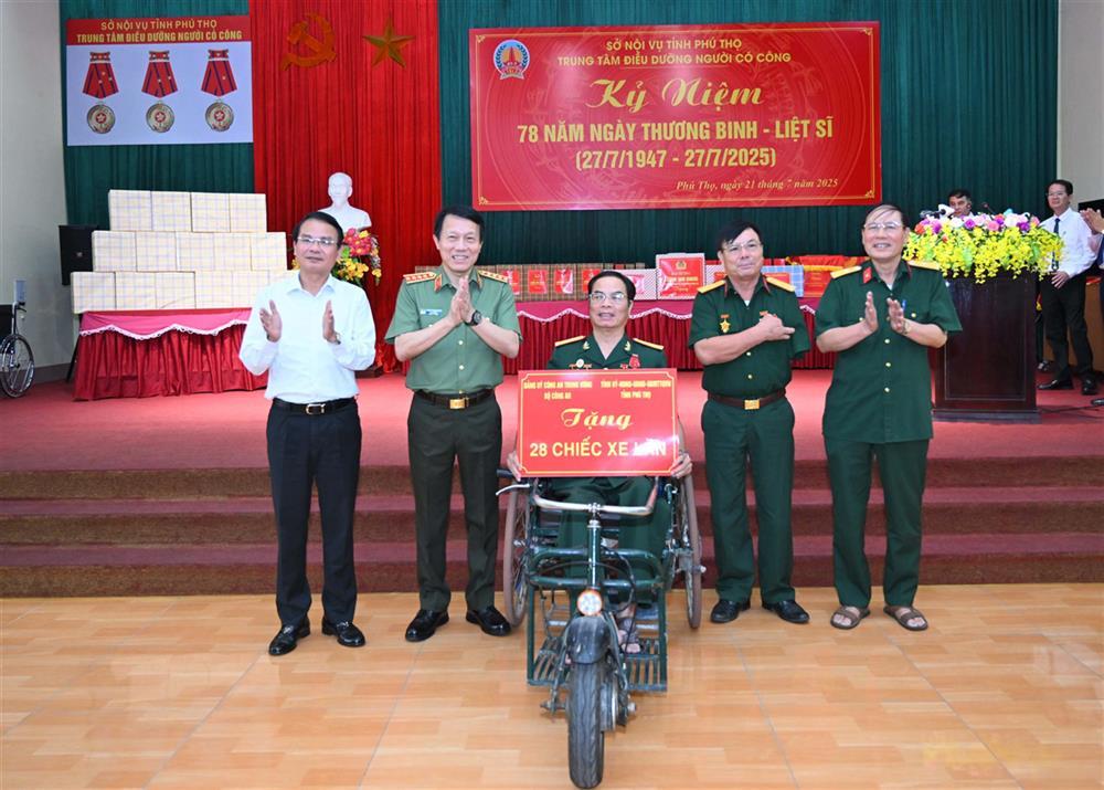 Minister Luong Tam Quang presents wheelchairs to disabled veterans.