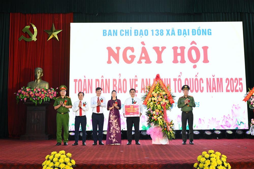 Deputy Minister Le Quoc Hung presents flowers to Dai Dong commune.