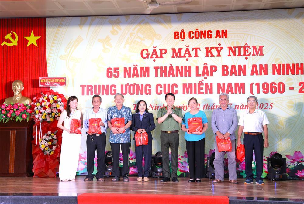 Minister Luong Tam Quang presents gifts to former southern security officers.