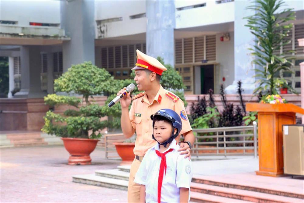 Binh Duong traffic police officers explain traffic safety regulations to local students.