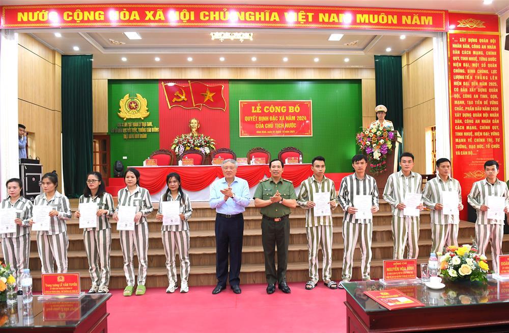 Permanent Deputy Prime Minister Nguyen Hoa Binh and Deputy Minister Lieutenant General Le Van Tuyen hand over amnesty certificates to inmates.