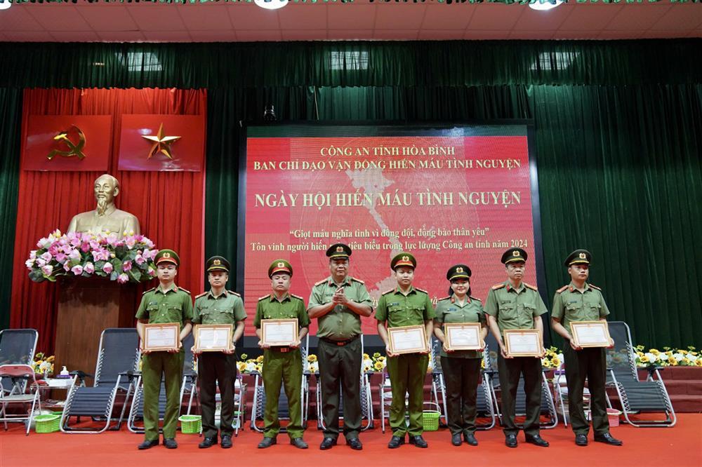 Senior Colonel Nguyen Thanh presents certificates of merit to typical individuals in 2024 voluntary blood donation movement.