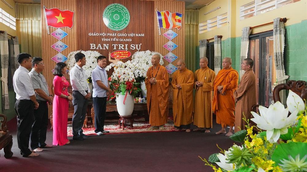 Senior Colonel Phan Van Trang presents flowers to Executive Board of Tien Giang Provincial Buddhist Sangha.