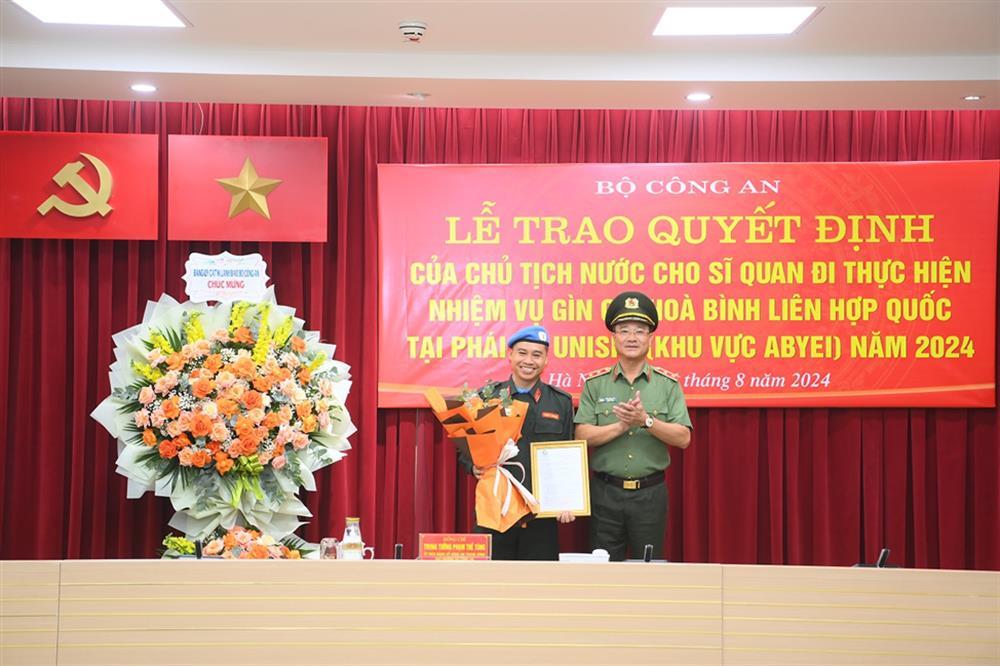 Deputy Minister Pham The Tung hands over President’s decision to Lieutenant Colonel Trinh Xuan Hien.