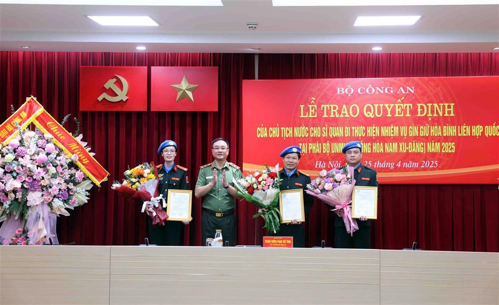 Deputy Minister Pham The Tung hands over President’s decisions to three police officers.