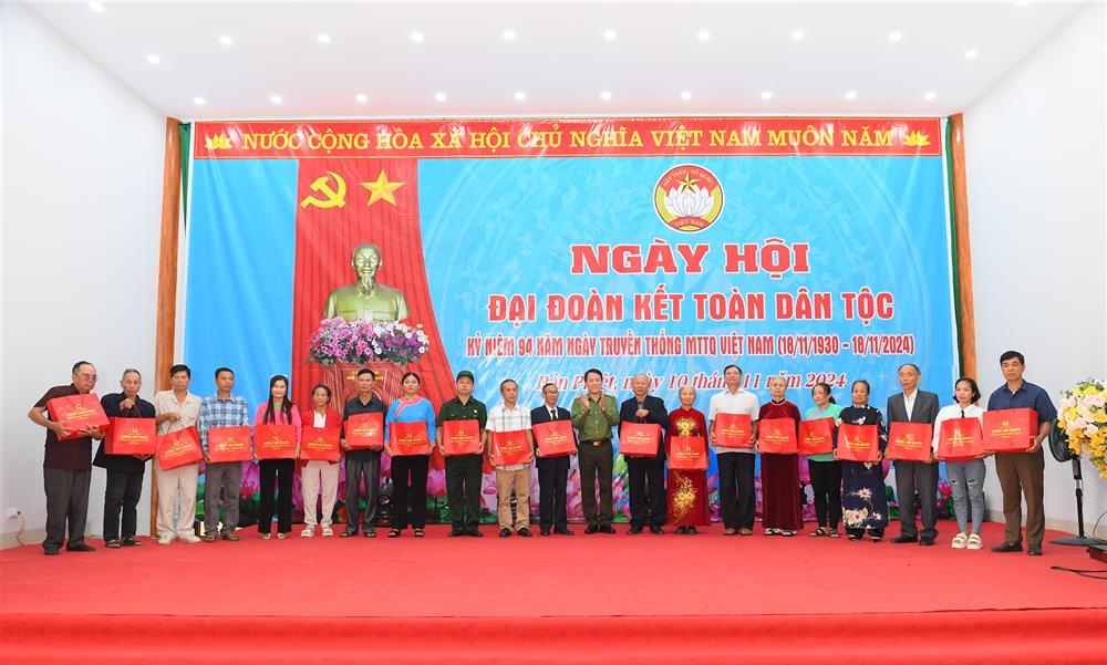 Minister Luong Tam Quang presents gifts to local people.