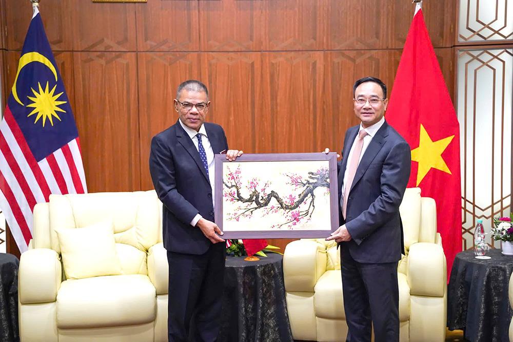 Deputy Minister Pham The Tung presents Minister Datuk Seri Saifuddin Nasution Ismail with souvenirs.