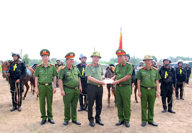 Deputy Minister Le Quoc Hung presents gifts to officers and soldiers at the unit.