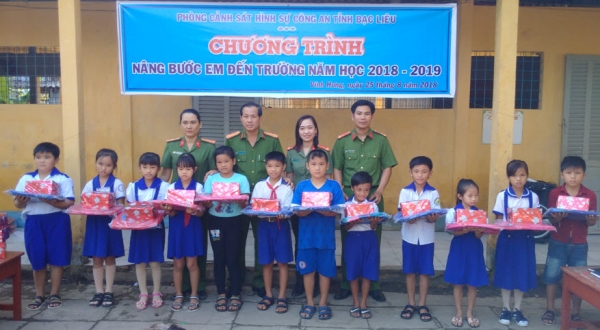 Officers of Criminal Police Office present gifts to poor students at Le Van Tam Primary School, Vinh Hung commune, VinhLoi district.