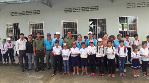 Officers of the Professional Techniques Office present gifts to poor students.