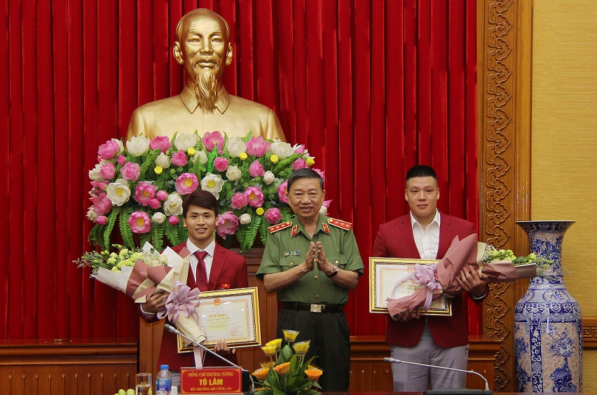 Minister To Lam presents Certificates of Merit to 2 athletes of the Public Security Forces.