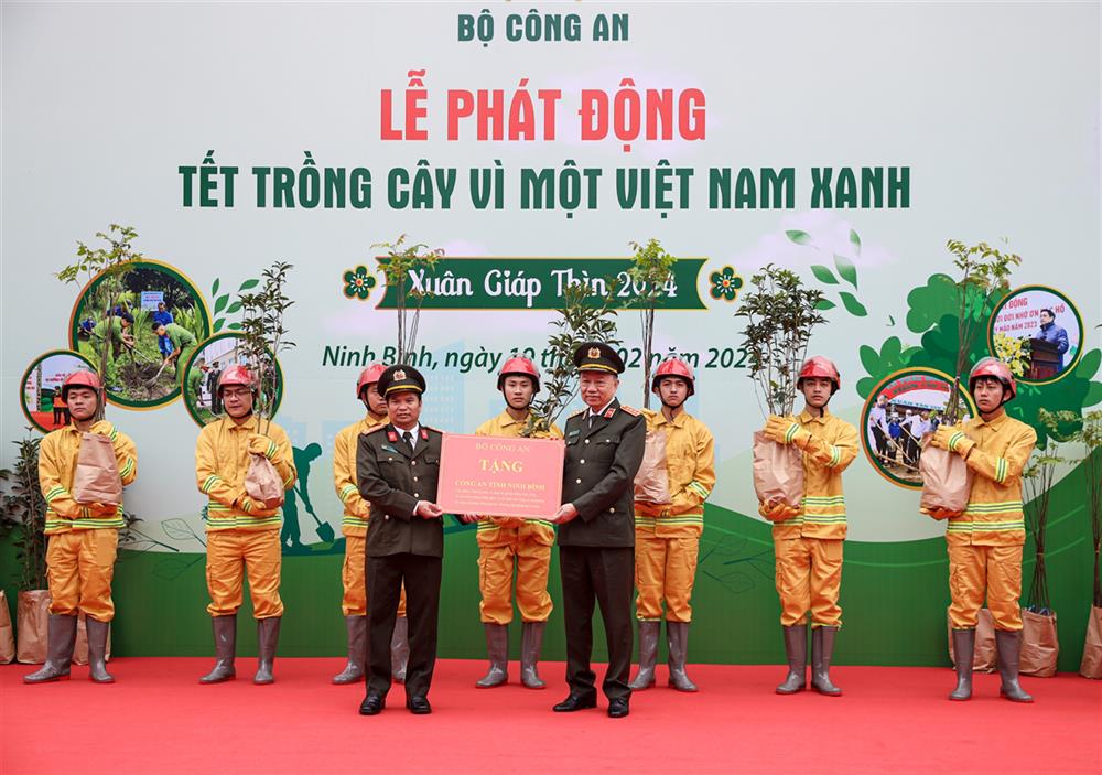 Minister To Lam presents seedlings to local police.